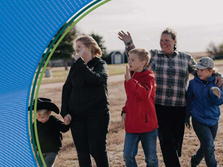 Farm safety awareness with children and adults outdoors in a rural setting.